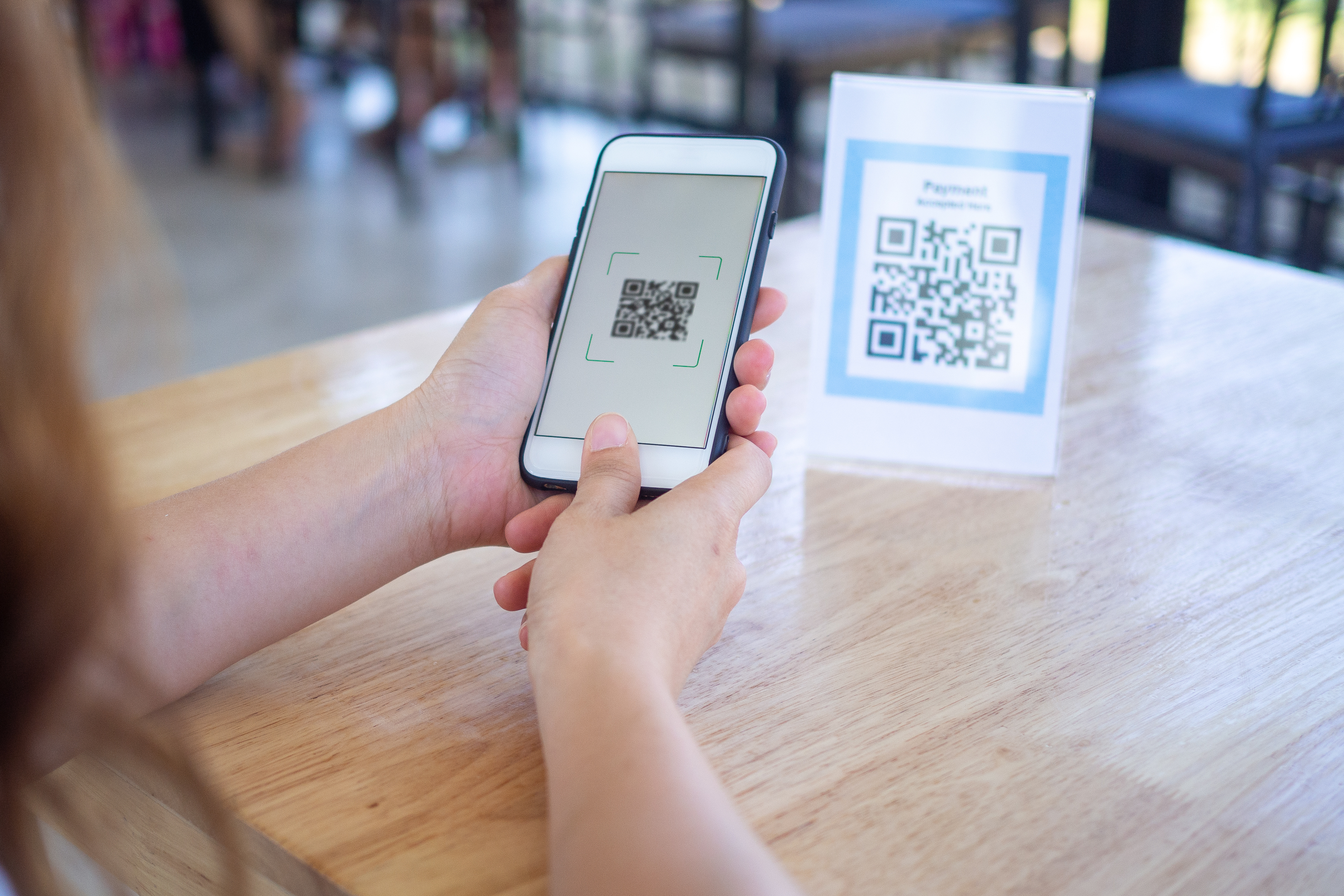 A lady scanning a QR code using her mobile phone