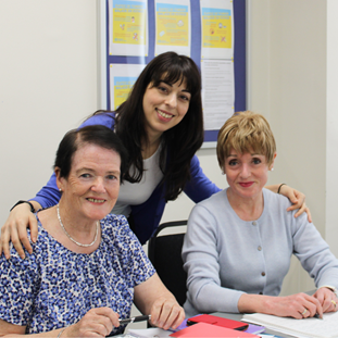 Brenda and Carmel in the classroom with their tutor, Maria.