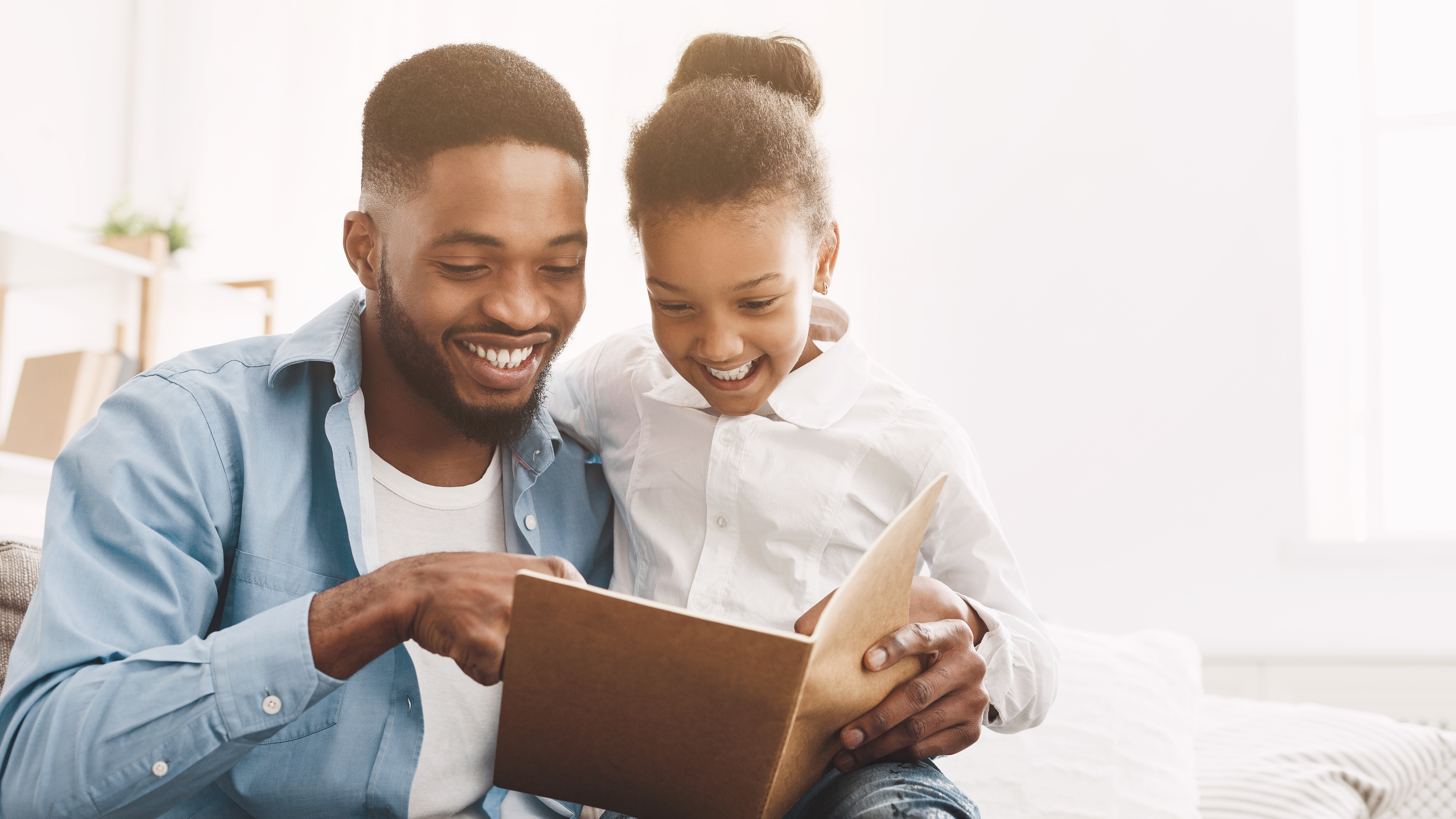 father and daughter reading a book together.