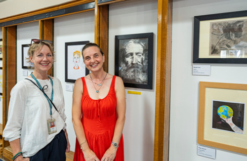 Betul, stood in front of her artwork, with her tutor.