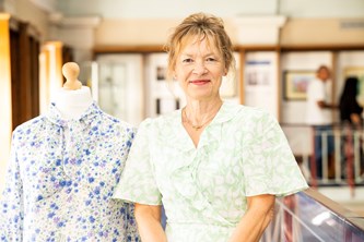 Female learner standing with her textile pieces